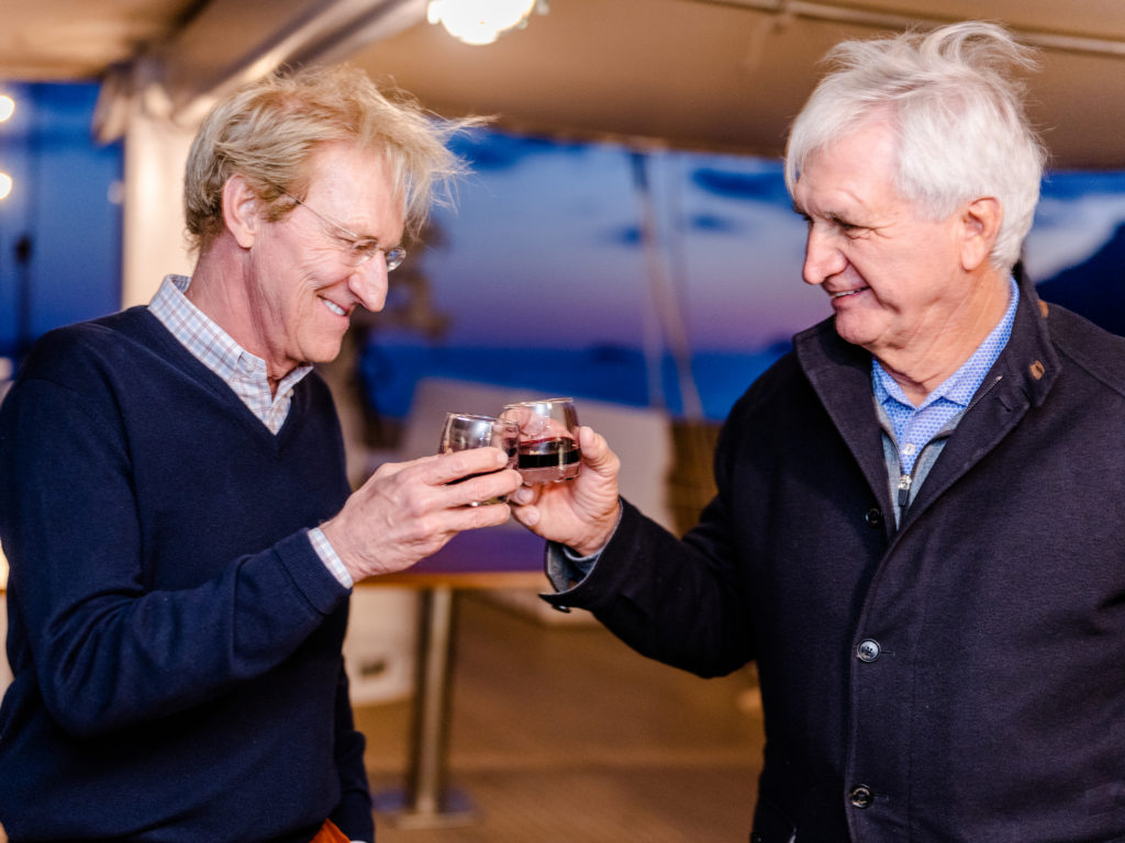 Men toasting small glasses of alcohol