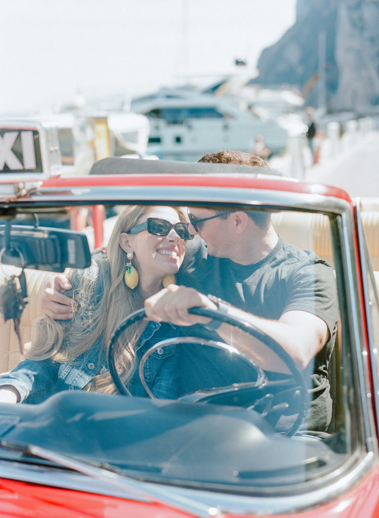 Couple smiling and driving a Fiat 1500 on Capri