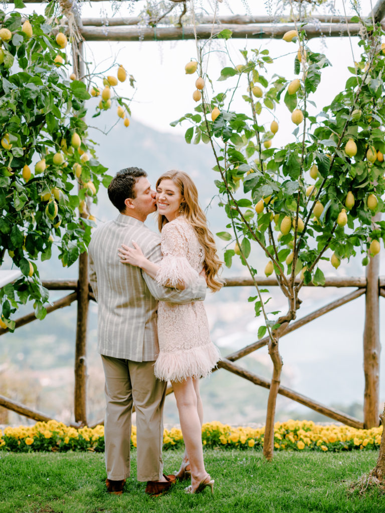 Couple kissing in front of lemon trees overlooking the Amalfi Coast