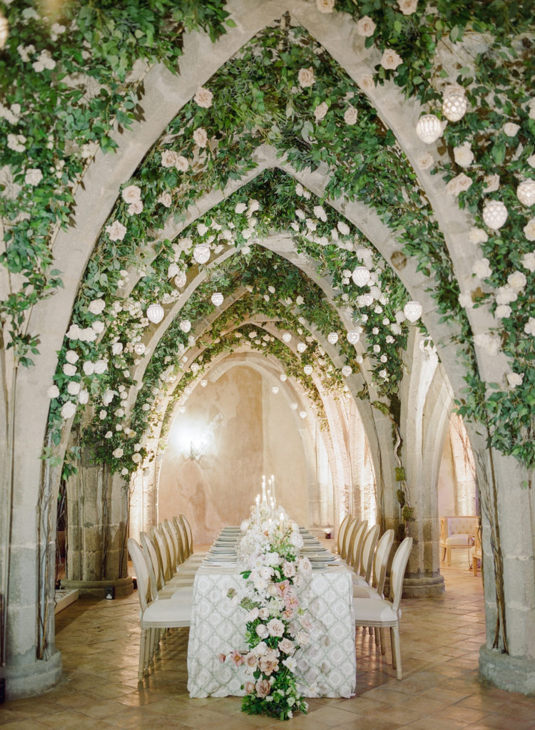 Amalfi Coast wedding reception table under stone archway with flowers